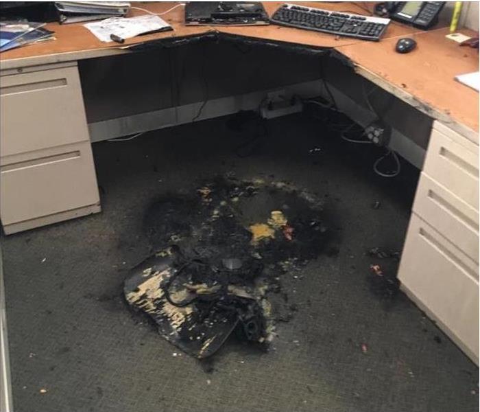 the burned item on the carpet, the desk has carbonized debris