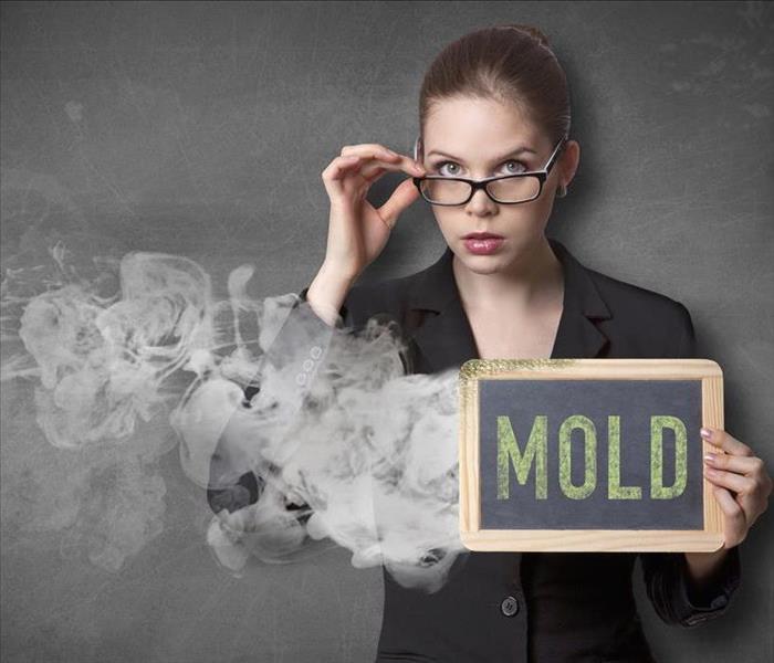 female holding a sign "Mold"