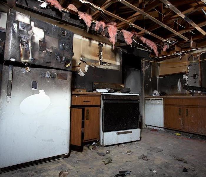 kitchen with fire damage and soot covering the fridge and all surfaces